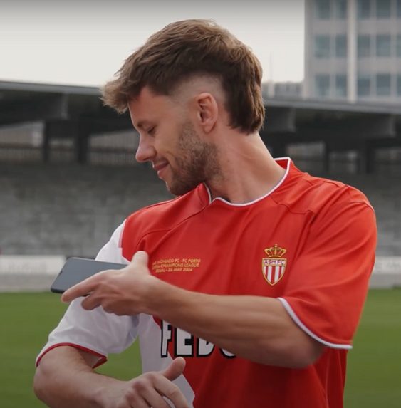 a man in a red shirt looking at his phone